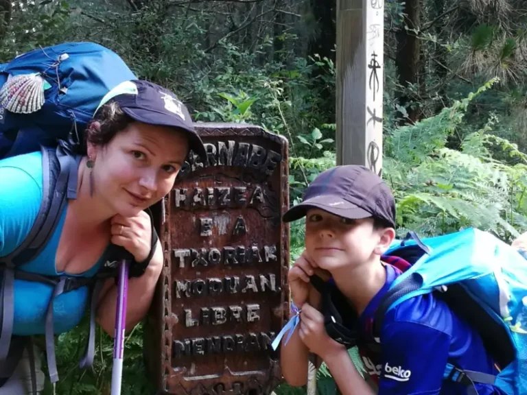 Femme et enfant randonneurs près d’un panneau forestier