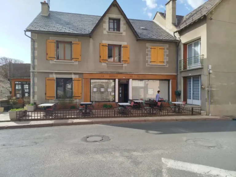Façade de café de village aux volets jaunes