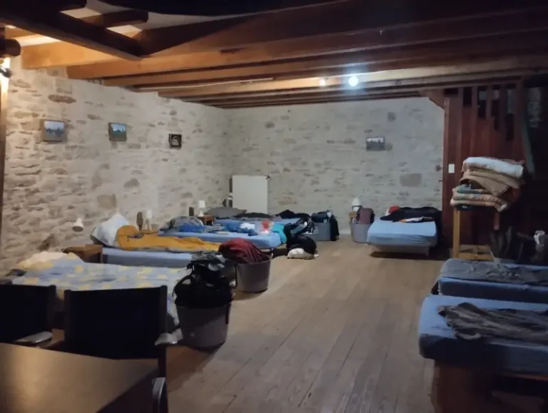 Chambre partagée avec lits et encadrements en bois.