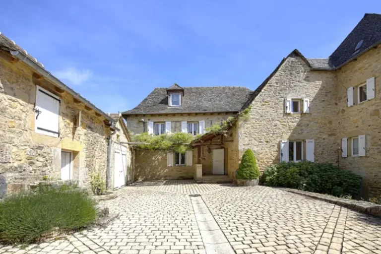Cour pavée entourée de maisons en pierre