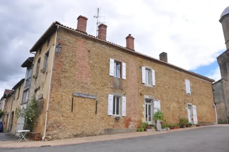 Maison en pierre avec volets blancs