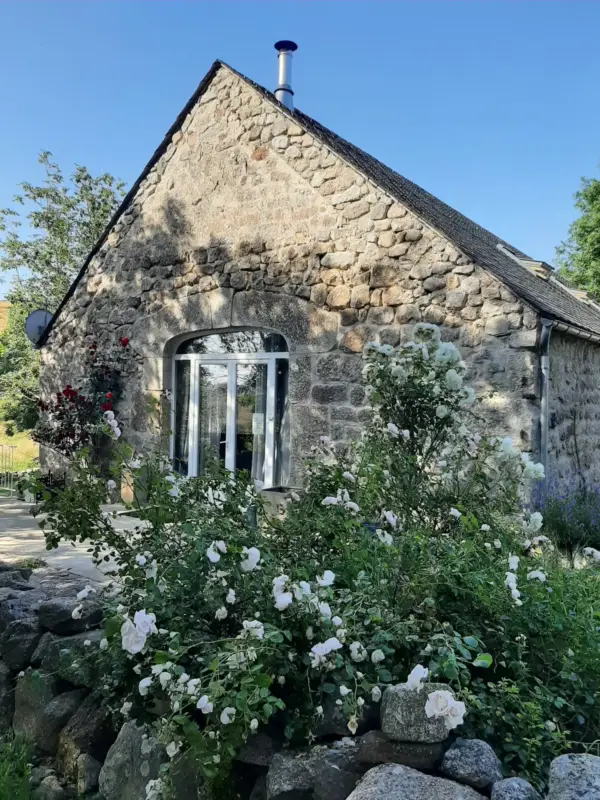 Petite maison en pierre avec jardin fleuri