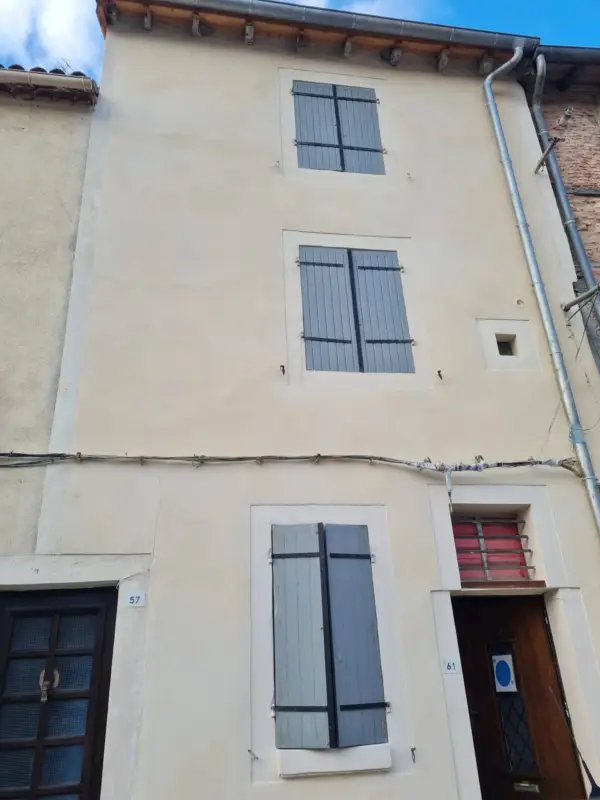 Façade d'une maison avec volets fermés.