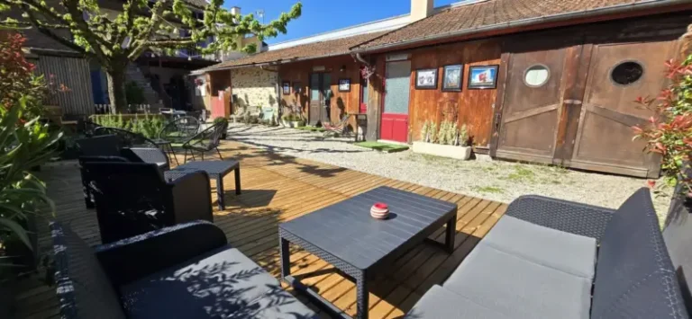 Cour intérieure ensoleillée avec terrasse et mobilier extérieur
