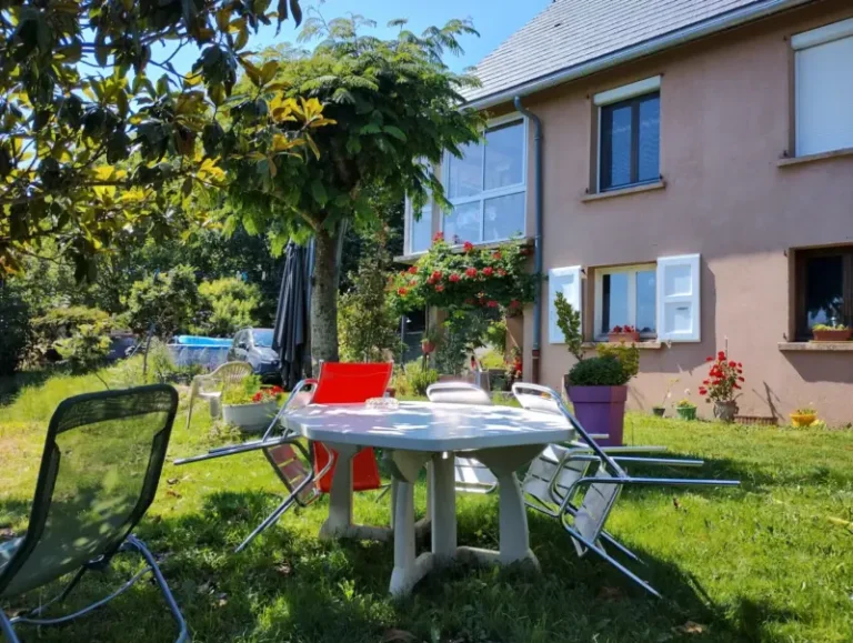 Jardin ensoleillé avec table et maison fleurie