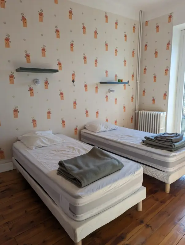 Chambre avec deux lits simples et papier peint