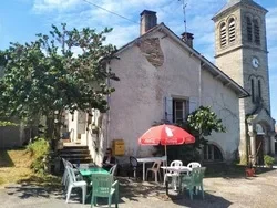 Maison ancienne avec terrasse et parasol rouge.