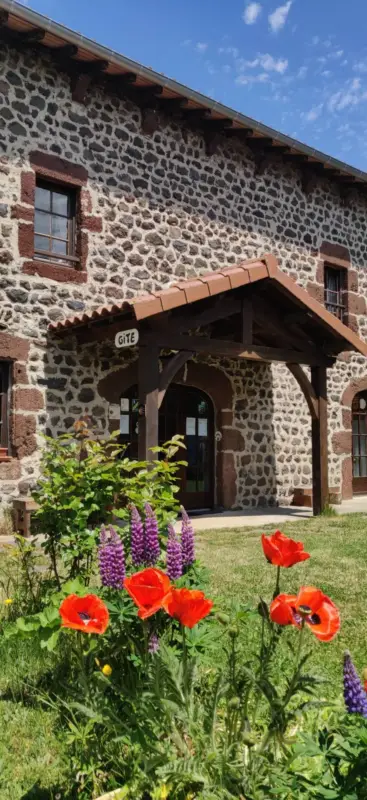 Maison en pierre avec fleurs au premier plan