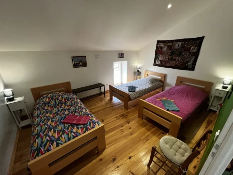 Chambre avec trois lits simples en bois