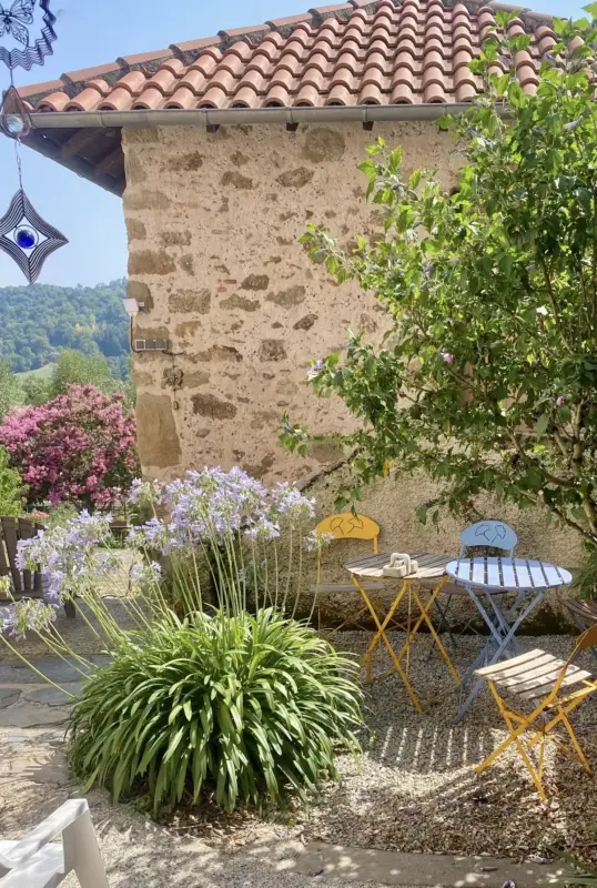 Jardin avec fleurs et chaises colorées ensoleillées.