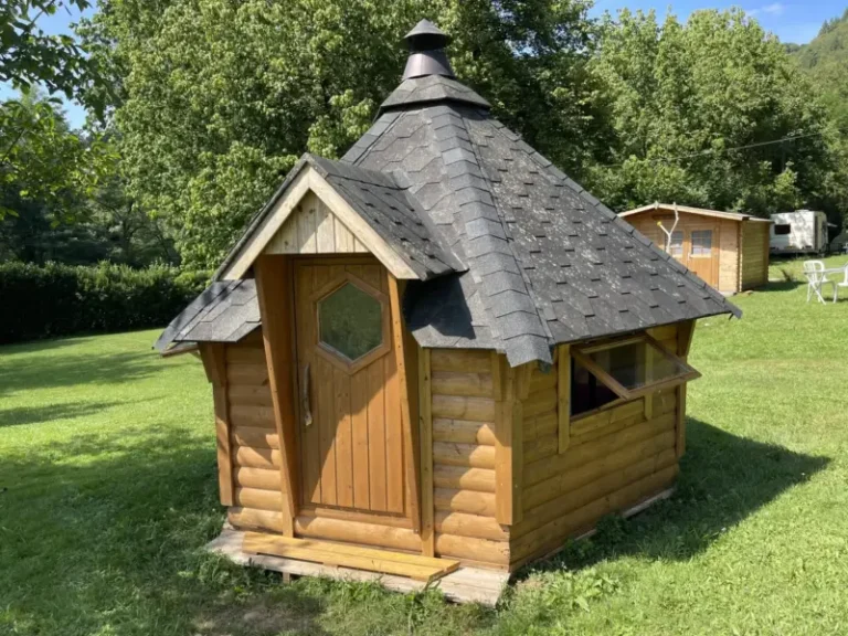Petite cabane en bois dans un jardin verdoyant