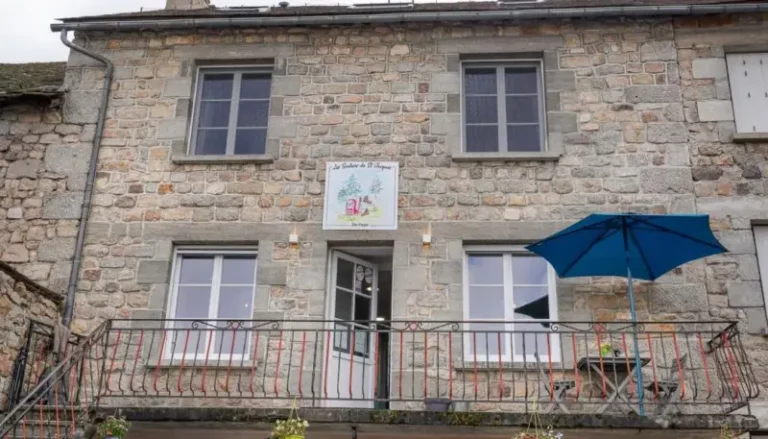 Façade en pierre avec balcon et parasol bleu