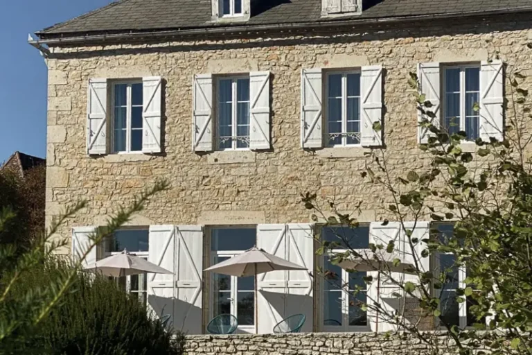 Maison en pierre avec volets blancs