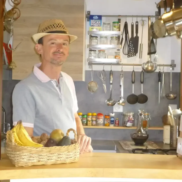 Homme dans une cuisine avec des fruits.