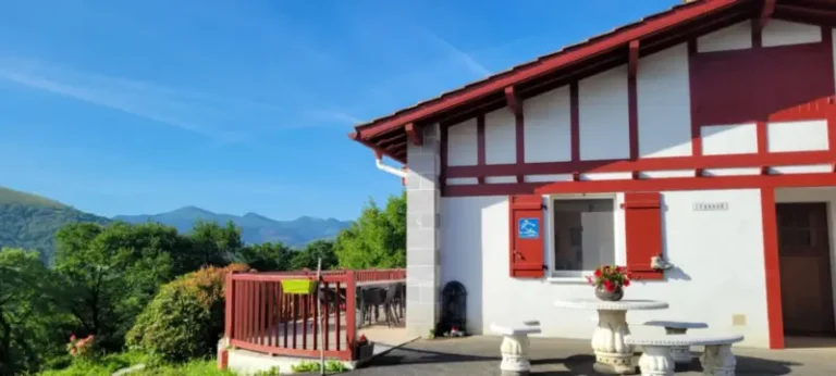 Maison blanche à colombages rouges avec terrasse