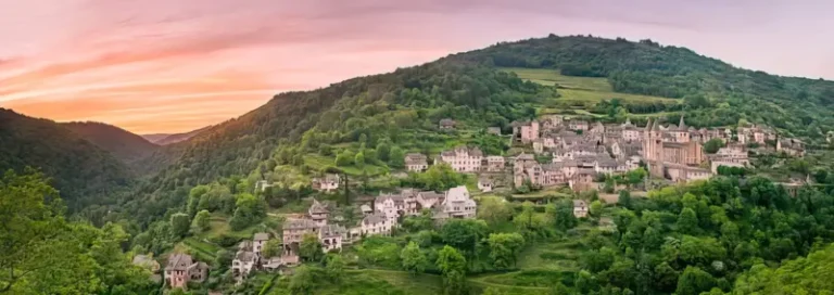 Panorama d'un village verdoyant au coucher du soleil.