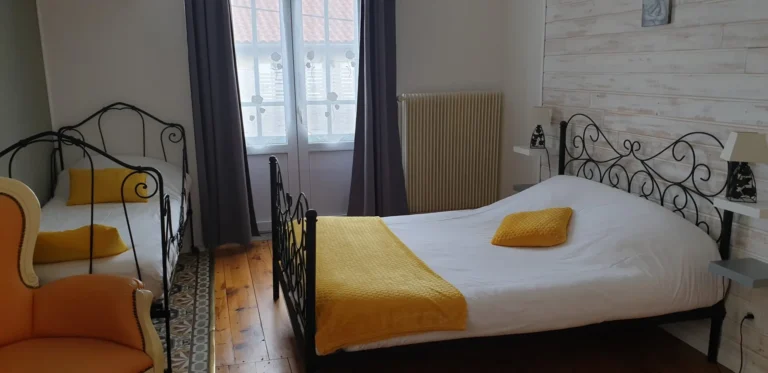 Chambre lumineuse avec lits en fer forgé jaunes