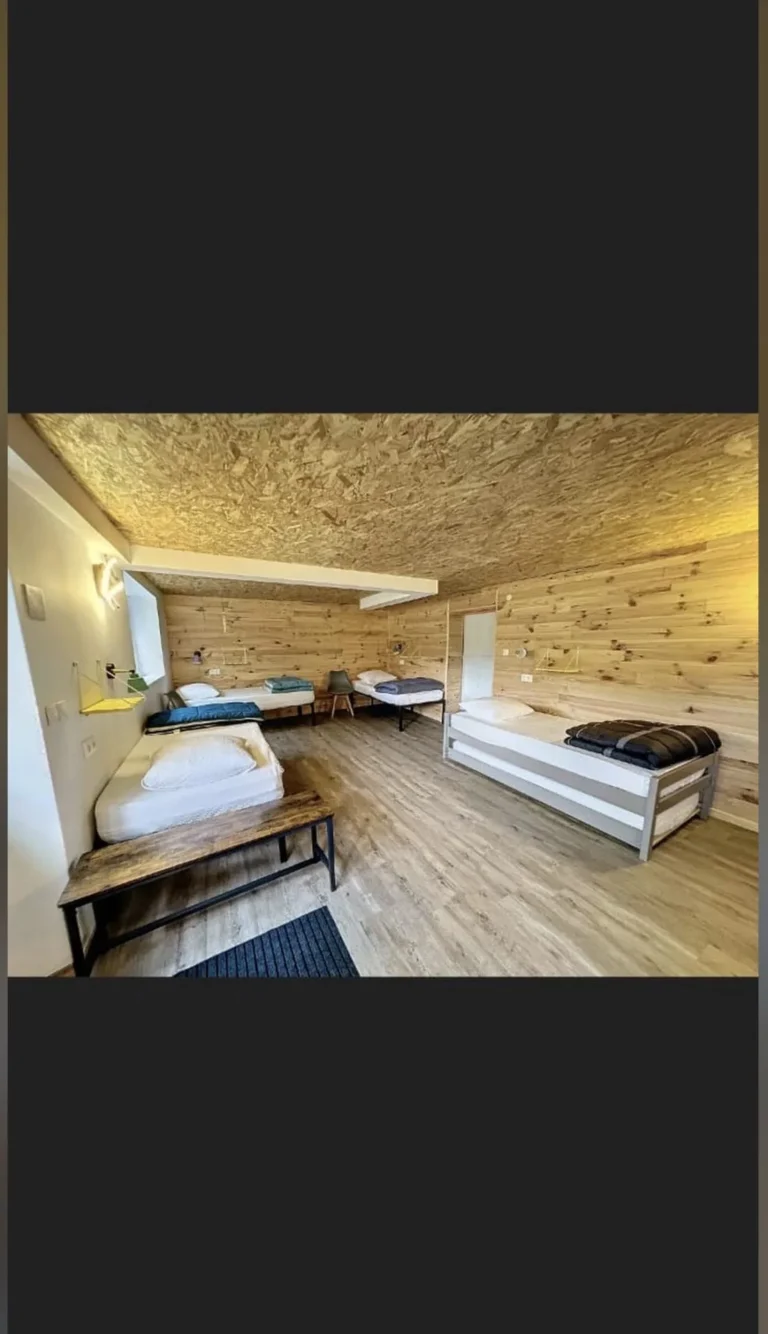 Chambre dortoir en bois avec cinq lits simples