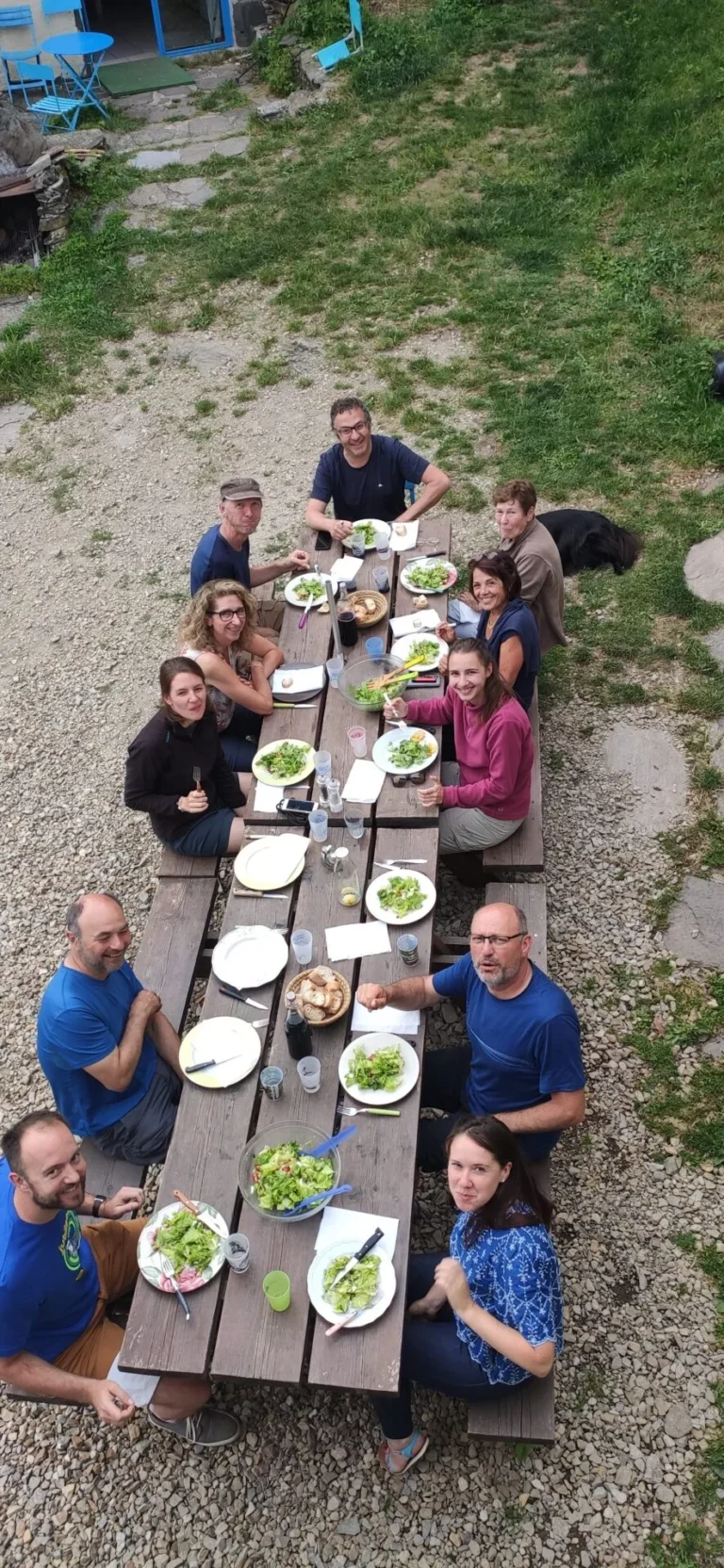Groupe de personnes partageant un repas en extérieur.