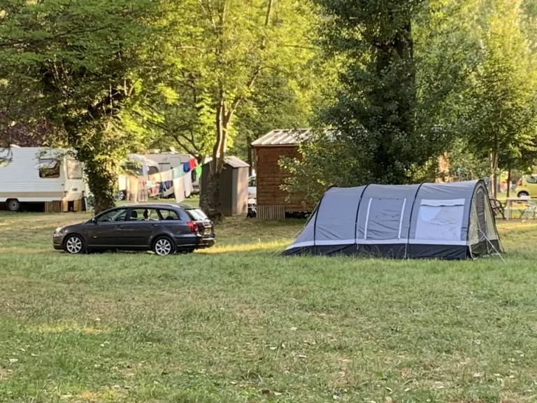 Tente et voiture dans un camping arboré