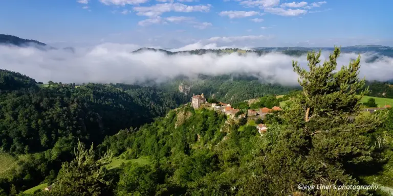 Village perché sur falaise au-dessus d’une vallée brumeuse