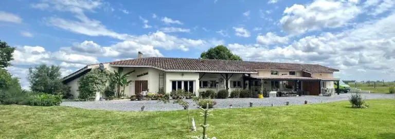 Grande maison moderne avec jardin et ciel bleu